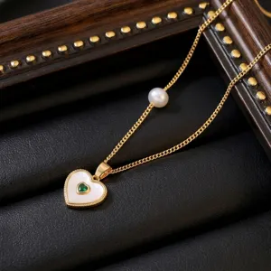 Detailed macro view of the titanium steel heart necklace with pearl and green gemstone.
