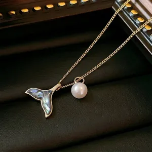 Close-up of titanium steel necklace with whale tail shell inlay and pearl pendant