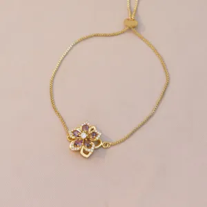 Vue détaillée d'un bracelet fleur rotatif doré avec cristaux violets et blancs