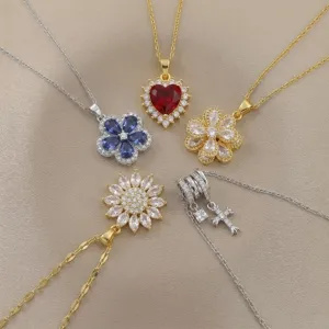 Vista detallada de varios collares de oro y plata con colgantes de corazón, flor y cruz