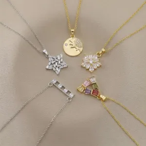Close-up of elegant necklaces featuring star, flower, and sun zircon pendants on fabric