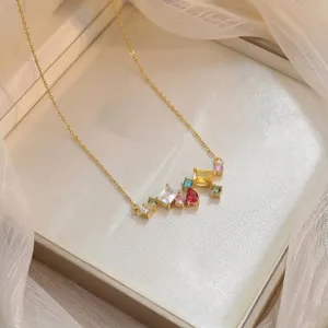 Close-up of fashion gold necklace with colorful multi-shape zircon pendant in gift box.