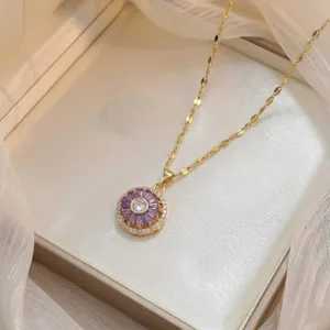 Primer plano de un collar dorado con colgante giratorio de circonitas púrpuras