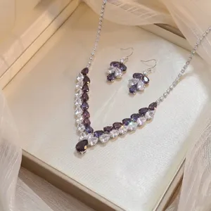Close-up of an elegant purple and white zirconia necklace and earring jewelry set