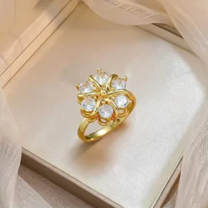 Detailed close-up of gold flower ring with micro-set cubic zirconia in a jewelry box