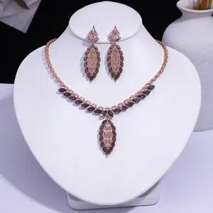 Luxurious pink and purple cubic zirconia necklace and earring set on white jewelry bust.