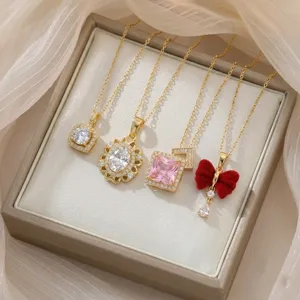 Detailed close-up view of four elegant gold zircon necklaces with pink and red bow pendants.