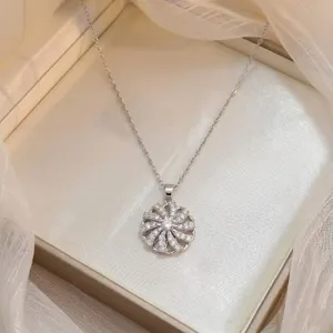 Gros plan élégant d'un pendentif fleur rotatif scintillant avec des zircons