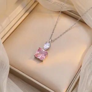Detail of pink square zircon and clear pear stone pendant on a silver-toned chain