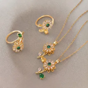 Detailed macro shot of elegant gold flower jewelry set featuring green zircon stones