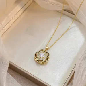 Collier fleur de camélia doré élégant avec pavé de zircons et accents d'émail noir.