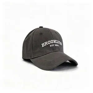 Nahaufnahme einer grauen Baseballkappe aus Baumwolle mit weißer Brooklyn-Stickerei.