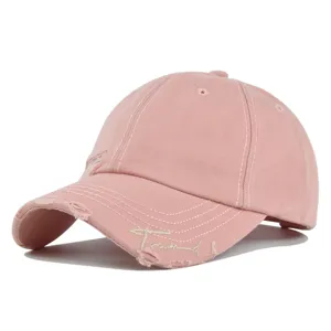 Detailaufnahme einer distressed rosa Baseballkappe mit Trend-Stickerei am Schirm