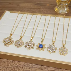 Selection of elegant gold-tone zircon pendant necklaces on a white jewelry tray
