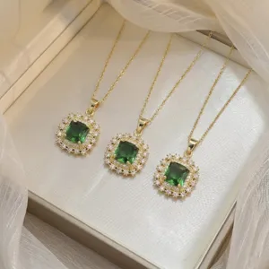 Close-up view of elegant emerald green zircon flower pendants on delicate gold chains