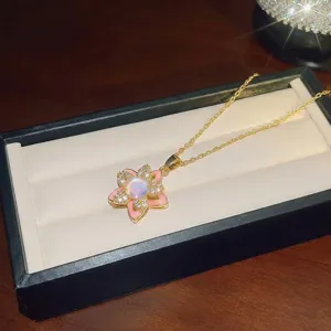 Gros plan d'un élégant collier avec pendentif fleur rose présenté dans un écrin à bijoux