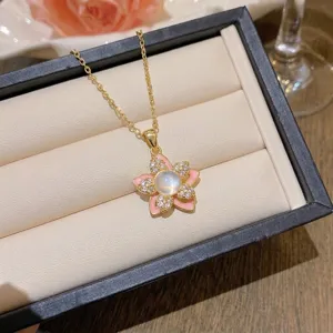 Détail du collier fleur à cinq pétales doré avec émail rose et oxydes de zirconium.