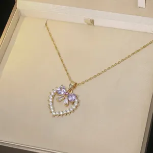 Gros plan d'un élégant collier en forme de cœur avec zircons violets dans un écrin