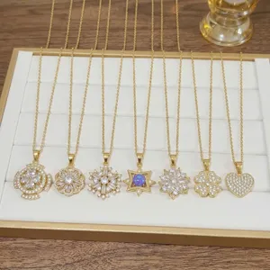 Detail view of assorted gold-plated necklaces featuring zirconia flower and heart pendants