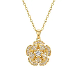 Close-up of elegant gold five-petal flower pendant necklace with pavé zircons