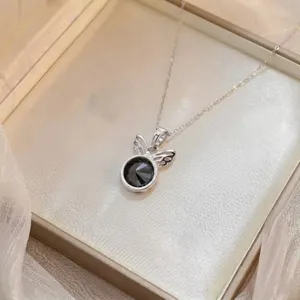 Gros plan détaillé d'un pendentif papillon en argent avec une pierre de zircon noir