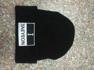Λεπτομέρεια του κεντημένου patch 'I TAEYEON' σε μαύρο πλεκτό σκουφάκι