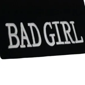 Détail d'un bonnet en tricot noir hip-hop avec broderie 3D blanche 'BAD GIRL' stylée