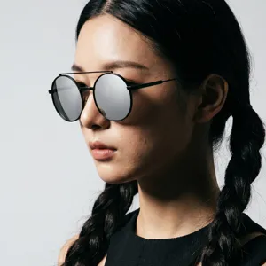 Zijaanzicht van een model met een ronde retro zonnebril met zilveren spiegelglazen