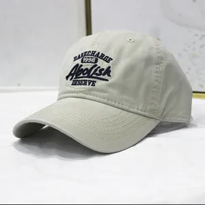 Detailansicht einer beige gewaschenen Baumwoll-Baseballkappe mit dunkelblauer Stickerei