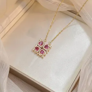 Primer plano de un collar chapado en oro con un colgante de corazón de circón rosa