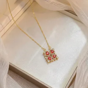 Vista detallada del collar de oro con cuatro piedras de circonita de corazón rojo