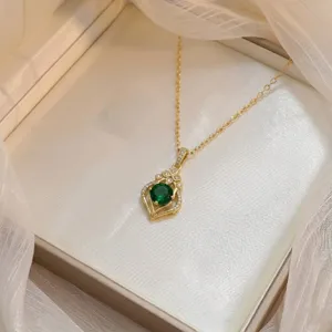 Gros plan d'un collier pendentif fleur avec une pierre de zircon vert émeraude ronde.