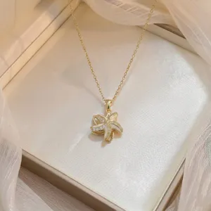 Gros plan détaillé d'un collier avec pendentif fleur doré orné de zircons scintillants