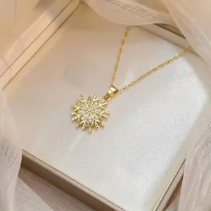Detailed view of a gold snowflake necklace pendant with sparkling cubic zirconia