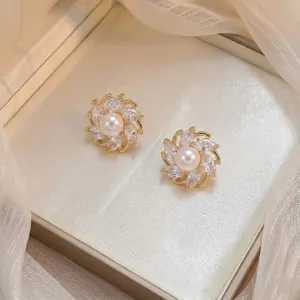 Vue détaillée de boucles d'oreilles en fleur avec perle centrale et zircons