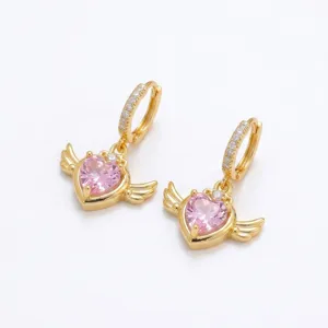 Vue détaillée de créoles dorées avec zircon rose en forme de cœur et ailes