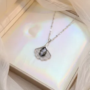 Vue détaillée d'un collier pendentif élégant en feuille de ginkgo avec zircon noir
