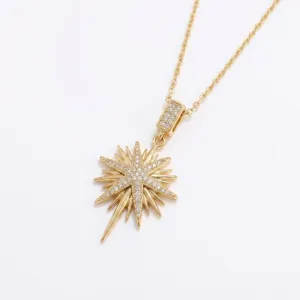 Détail d'un collier avec pendentif étoile dorée et zircons cubiques scintillants.
