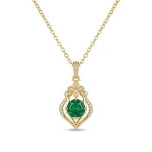 Vue détaillée d'un collier en or avec pendentif floral et pierre précieuse verte ronde.