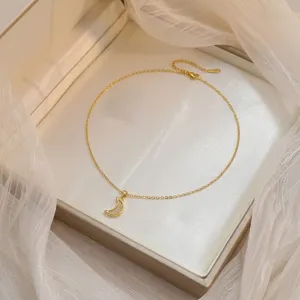 Détail d'un pendentif lune en or serti de zircons scintillants sur une chaîne fine