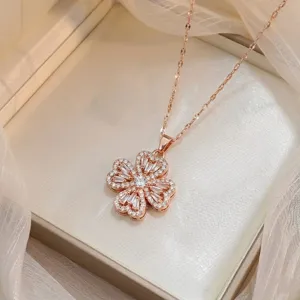 Gedetailleerde macro-opname van een roségouden roterende klavertje vier ketting met kristal