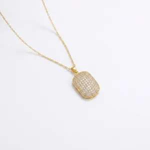 Gros plan d'un collier plaqué or avec un pendentif rectangulaire entièrement pavé de zircons