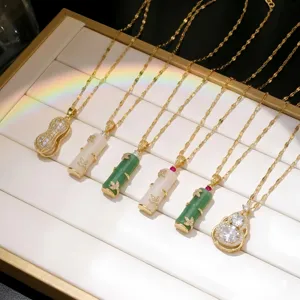 Detailed view of 18K gold plated bamboo and gourd pendants with jadeite and crystals.