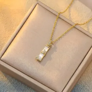 Detail shot of golden bamboo necklace with pearlescent chalcedony pendant and rhinestones