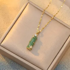 Close-up of elegant green chalcedony bamboo pendant with gold leaf and diamond accents