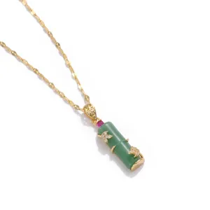 Detailed view of a green jade-like bamboo pendant necklace with a fine gold chain.