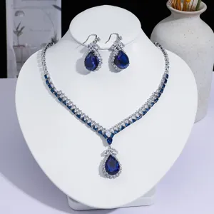 Gros plan détaillé d'un élégant ensemble de bijoux collier et boucles d'oreilles bleu.