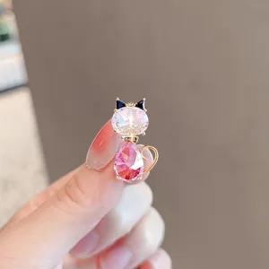 Crystal cat brooch detail, pink gemstone lapel pin, elegant fashion jewelry accessory.