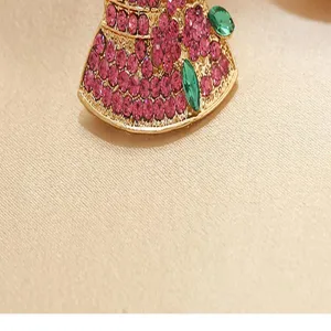 Detailed close-up view of a creative rhinestone hat brooch pin showing sparkling pink and green gems.