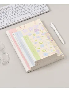 Draadgekleefd gelinieerd notitieboek detailweergave met bloemendesign en nette stapel.